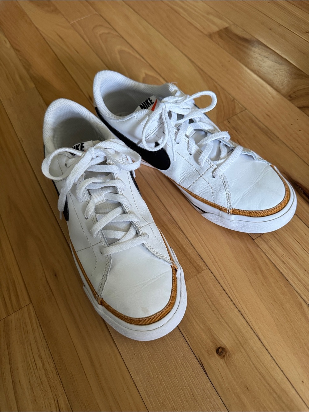 Nike White Kids Sneakers with Black Swoosh and Gold Trim